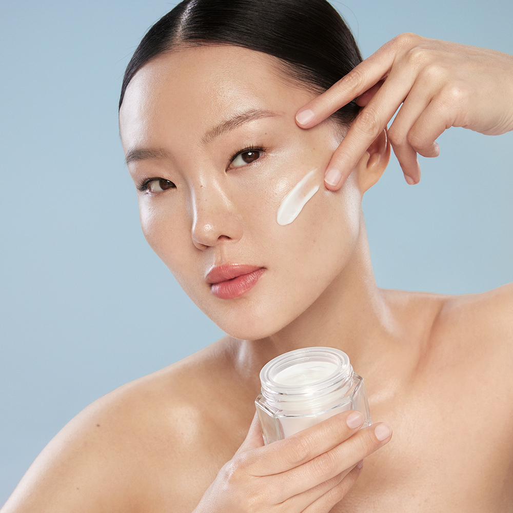 Woman applying moisturizer